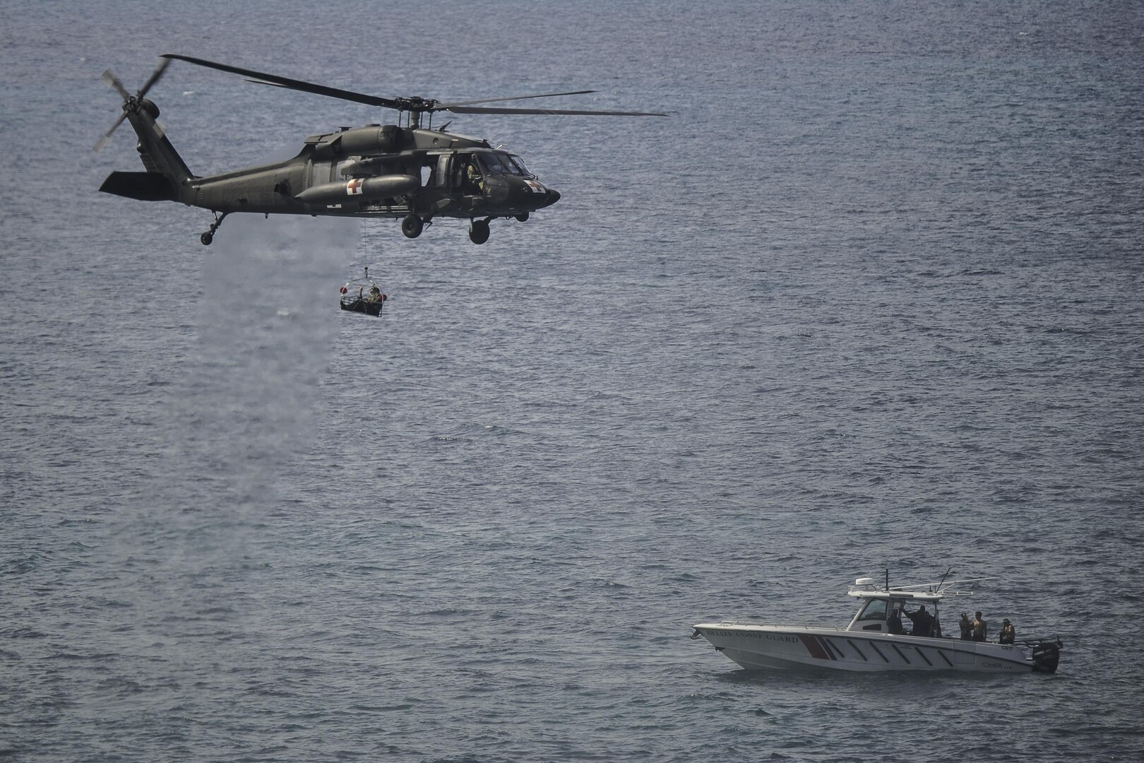 A UH-60L Black Hawk assigned to Joint Task Force-Bravo’s 1st Battalion, 228th Aviation Regiment carries a role player acting as a patient during medical evacuation training off the coast of Belize City, July 18, 2016. The 1-228th AVN’s U.S. Air Ambulance Detachment Honduras handles all of the battalion’s aeromedical operations, which include both training partner nations and providing real-world MEDEVAC capabilities throughout Central America. (U.S. Air Force photo by Staff Sgt. Siuta B. Ika) 