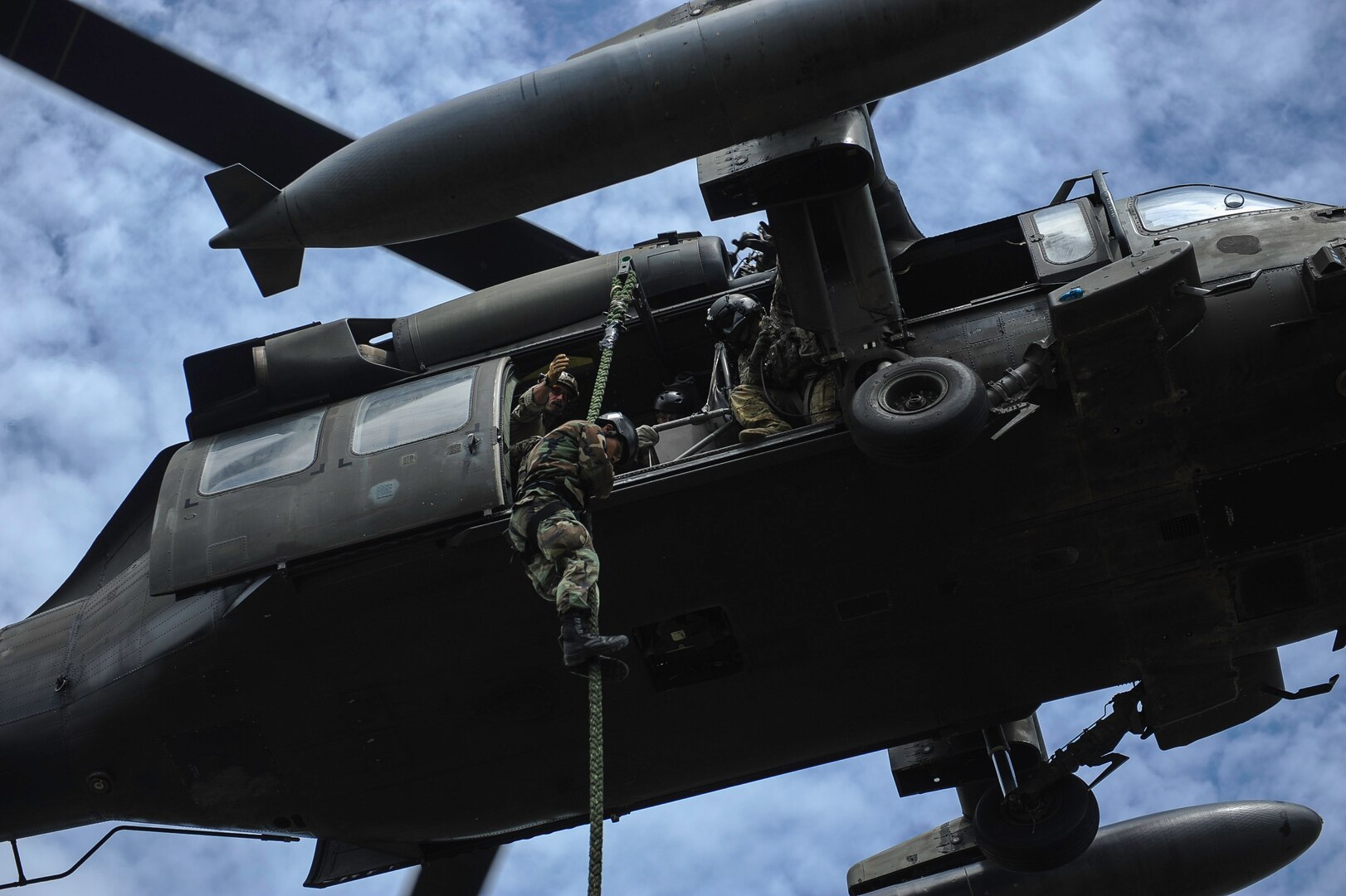 A member of the Belize Special Assignment Group fast ropes out of a UH-60 Black Hawk assigned to Joint Task Force-Bravo’s 1st Battalion, 228th Aviation Regiment during training at Price Barracks, Belize, July 19, 2016. The 1-228th AVN conducted Fast Rope Insertion and Extraction System (FRIES) training, helocast operations and recovery with the Jacobs Ladder, and open water hoist training with members of the BSAG and Belize Coast Guard. (U.S. Air Force photo by Staff Sgt. Siuta B. Ika)