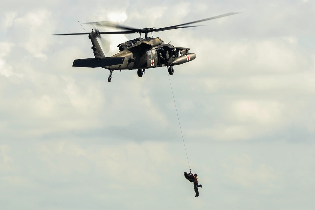 U.S. Army Staff Sgt. Jun Ma, a flight paramedic assigned to the 1st Battalion, 228th Aviation Regiment, utilizes a hoist from a UH-60L Black Hawk to extract a role player acting as a patient during an open water hoist training scenario off the coast of Belize District, July 21, 2016. Typical missions conducted by Joint Task Force-Bravo’s 1-228th AVN include counter-drug operation support and training, disaster relief, humanitarian assistance, air movement of people, equipment and supplies, aeromedical evacuation, and search and rescue.  (U.S. Air Force photo by Staff Sgt. Siuta B. Ika)