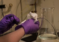 Senior Airman Christopher Buccieri, 375th Logistical Readiness Squadron fuels laboratory technician, tests a fuel sample to determine the presence of particulates. (U.S. Air Force photo by Staff Sgt. Martinez/Released)