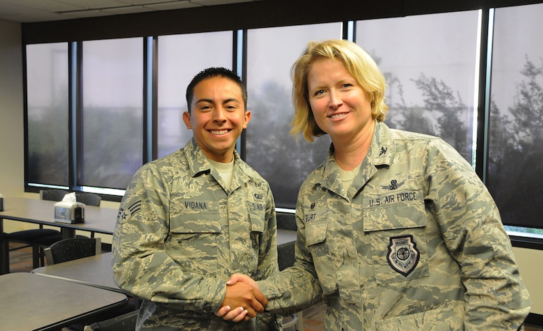 Col. DeAnna Burt, 50th Space Wing commander, and Senior Airman Darian Vidana, 50th Comptroller Squadron, pose for a photo after Vidana was coined for exceptional service during the Airman’s breakfast at Schriever Air Force Base, Colorado, Tuesday, Aug. 2, 2016. Vidana was recognized for going out of his way to perform honor guard service for a recent funeral, despite no longer being detailed to honor guard. (U.S. Air Force photo/Airman William Tracy)