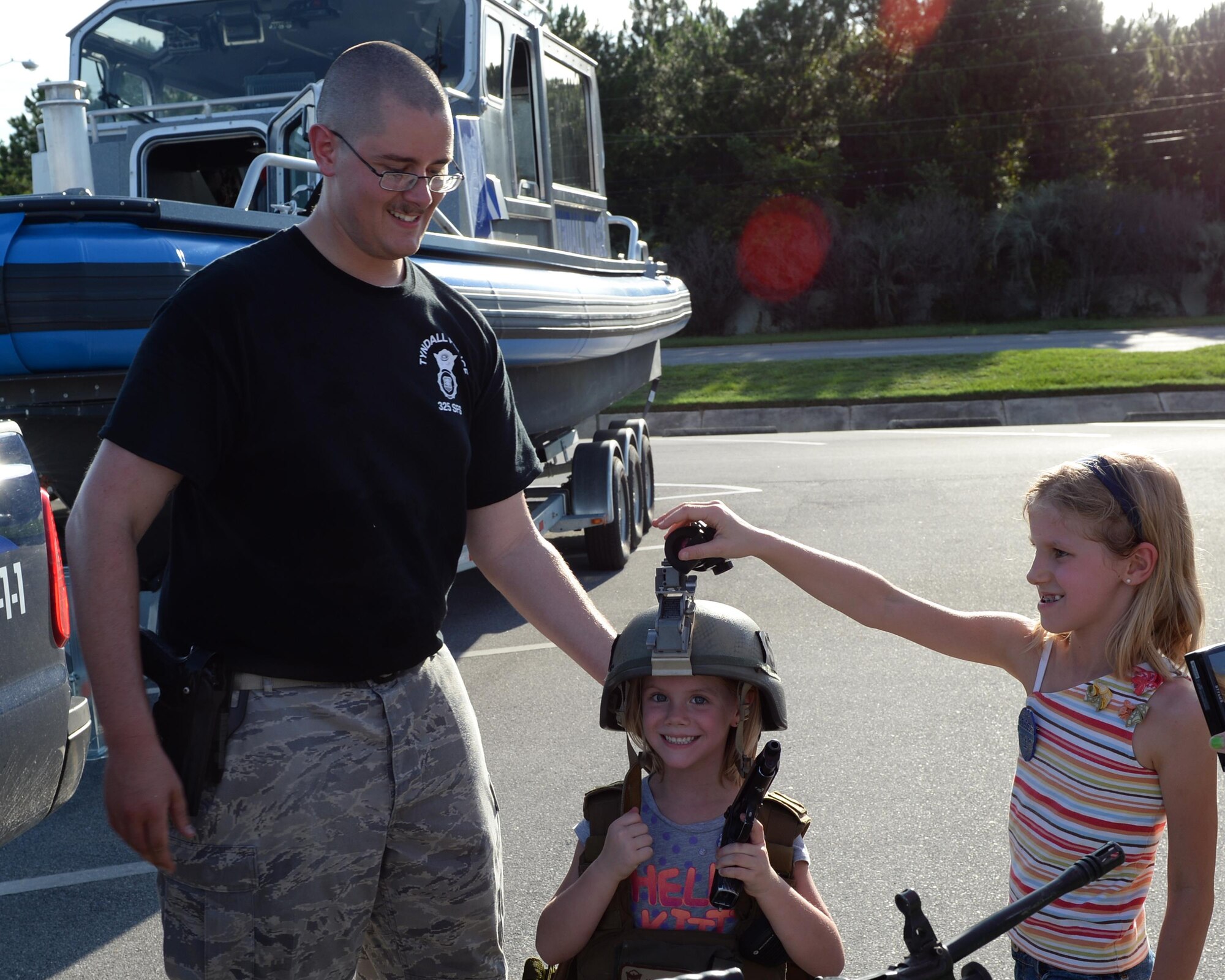 U.S. Air Force Senior Airman Caleb Imel, 325th Security Forces Squadron response force leader, shows children how to wear body armor during National Night Out at the Panama City Mall, Fla., Aug. 2, 2016. The event was a way for Federal, State and local law enforcement responders, as well as local fire departments and ambulance services, to interact with their respective communities in a fun and educational way. (U.S. Air Force photo by Airman 1st Class Cody R. Miller/ Released)
