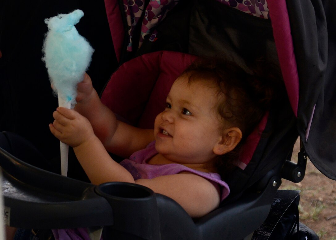 Avalynn Mendoza, 1, daughter of Senior Airman Manuel Mendoza, 56th Medical Operations Squadron medical aerospace technician, enjoys cotton candy during the Back to School Bash Aug. 2, 2016 at Luke Air Force Base, Ariz. The event was sponsored by the Luke Chapel as a way to give back to the community as well as prepare children for the upcoming school year. More than 500 people came out for the event. (U.S. Air Force photo by Senior Airman Devante Williams)