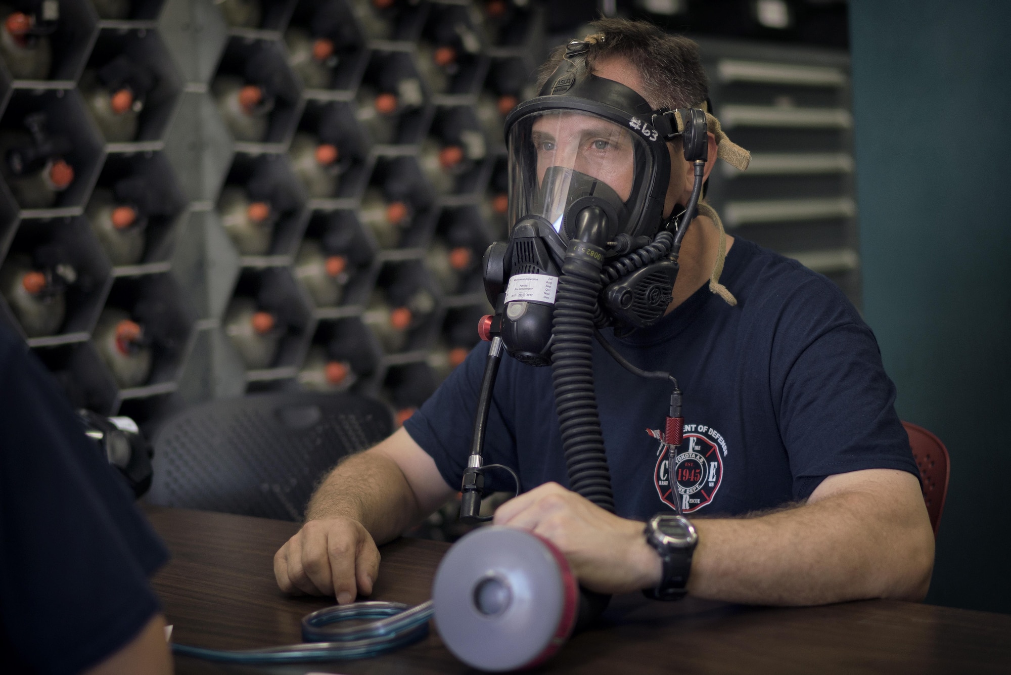 Col. Scott Maskery, 374th Mission Support Group commander, tries on a firefighting mask before engaging in fire training at Yokota Air Base, Japan, Aug. 1, 2016. Maskery suited up to learn about the processes and how Yokota firefighters operate as a team. (U.S. Air Force photo by Senior Airman Delano Scott/Released)