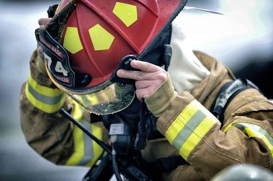 Staff Sgt. Bryan Schroeder, 374th Civil Engineer Squadron firefighter, removes his helmet after battling a simulated aircraft fire at Yokota Air Base, Japan, Aug. 1, 2016. Yokota firefighters train daily to ensure that they are prepared to respond to a variety of potential emergency situations. (U.S. Air Force photo by Senior Airman Delano Scott/Released) 
