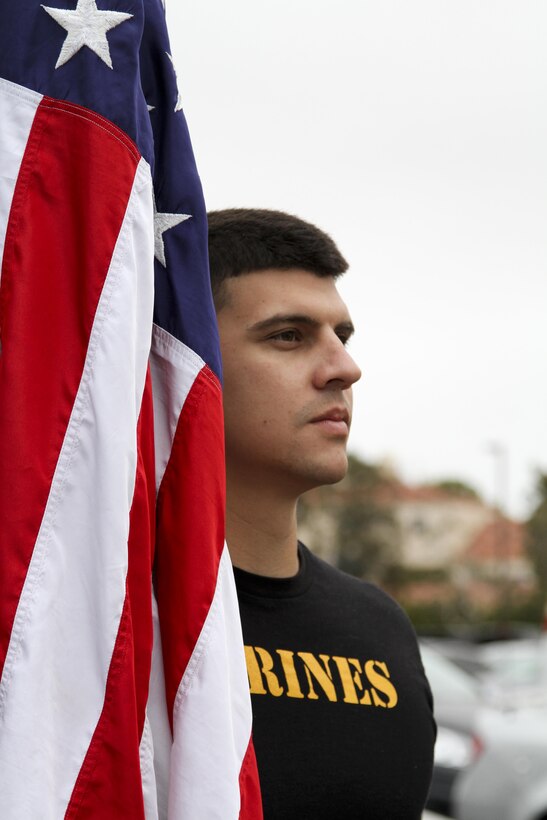 Sergeant Michael Losey, a canvassing recruiter at Recruiting Substation Mission Viejo, stands with the American Flag before a beach run at Huntington State Beach June 10, 2016. The purpose of the approximately four mile physical training session was to build morale, camaraderie and to conduct a reenlistment ceremony in the water for Gunnery Sgt. Kevin Aguilar and Sgt. Victor Galvan, both canvassing recruiters with Marine Corps Recruiting Station Orange County. (U.S. Marine Corps photo by Sgt. Vanessa Jimenez)