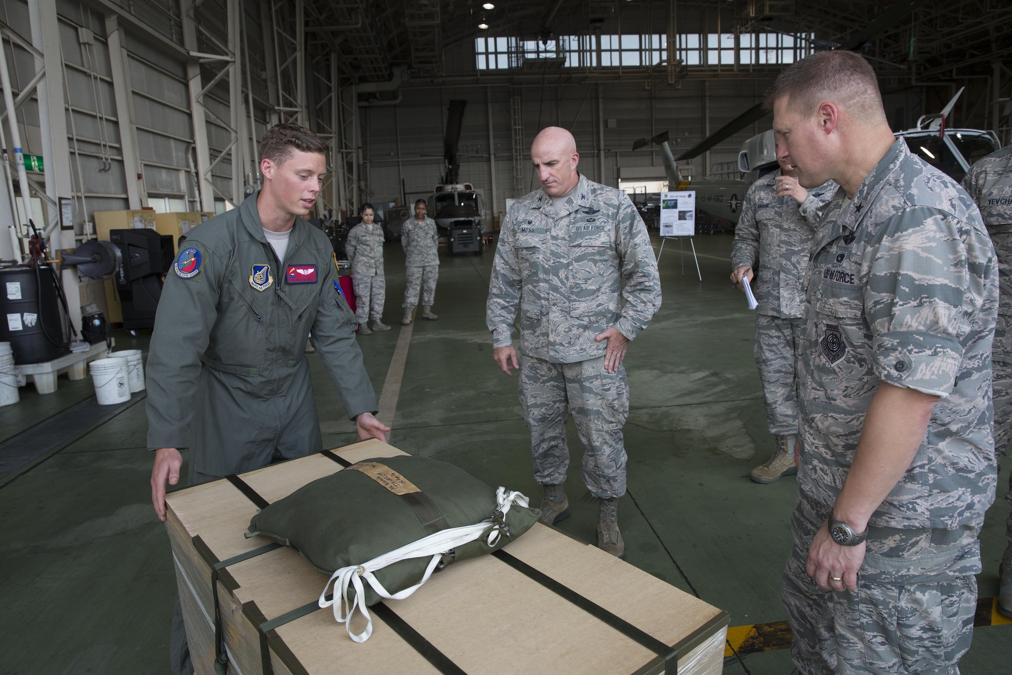 Senior Airman Nathanial Bennett, 374th Operation Support Squadron joint airdrop inspector, explains a low-cost, low-altitude bundle to Brig. Gen. Michael Winkler, 5th Air Force vice commander, at Yokota Air Base, Japan, Aug. 2, 2016. Winkler spent the day touring facilities throughout Yokota to learn more about the installation’s capabilities. (U.S Air Force photo by Yasuo Osakabe/Released) 