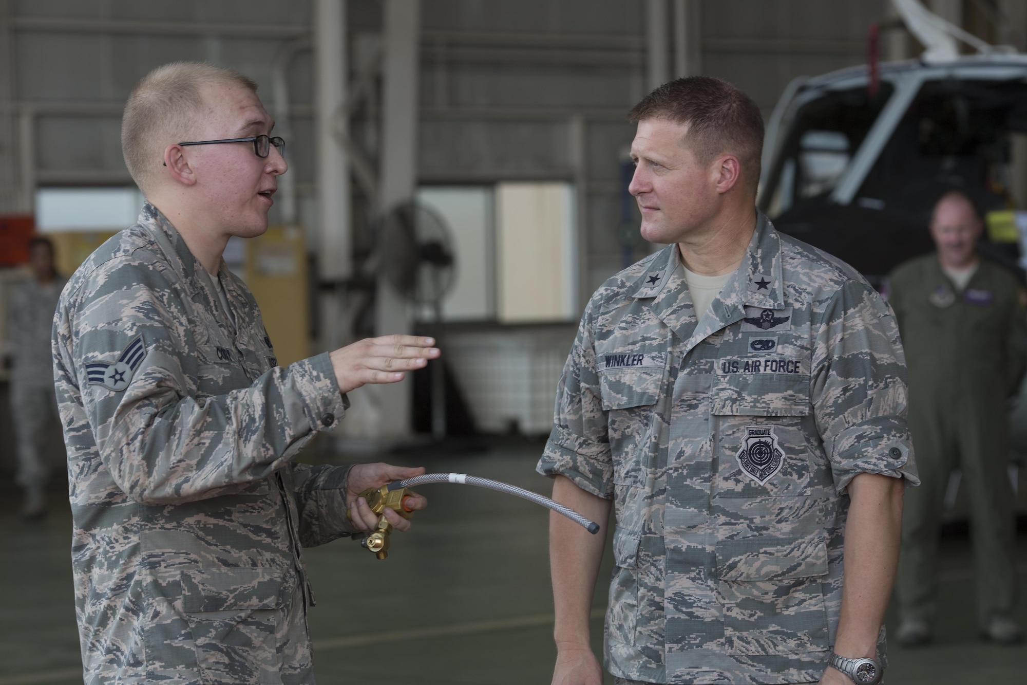 Senior Airman Zachary Cody, left, 374th Operations Support Squadron aircrew flight equipment journeyman, gives a brief description of the F-2B life raft inflating system to Brig. Gen. Michael Winkler, second from the left, 5th Air Force vice commander, during his immersion tour at Yokota Air Base, Japan, Aug. 2, 2016. Aircrew Flight Equipment specialists with the 374th Operations Support Squadron make sure aircrew have the supplies necessary for their missions. The team of AFE Airmen pack emergency items such as parachutes and survival kits and also maintain helmets and oxygen masks. (U.S. Air Force photo by Yasuo Osakabe/Released)  