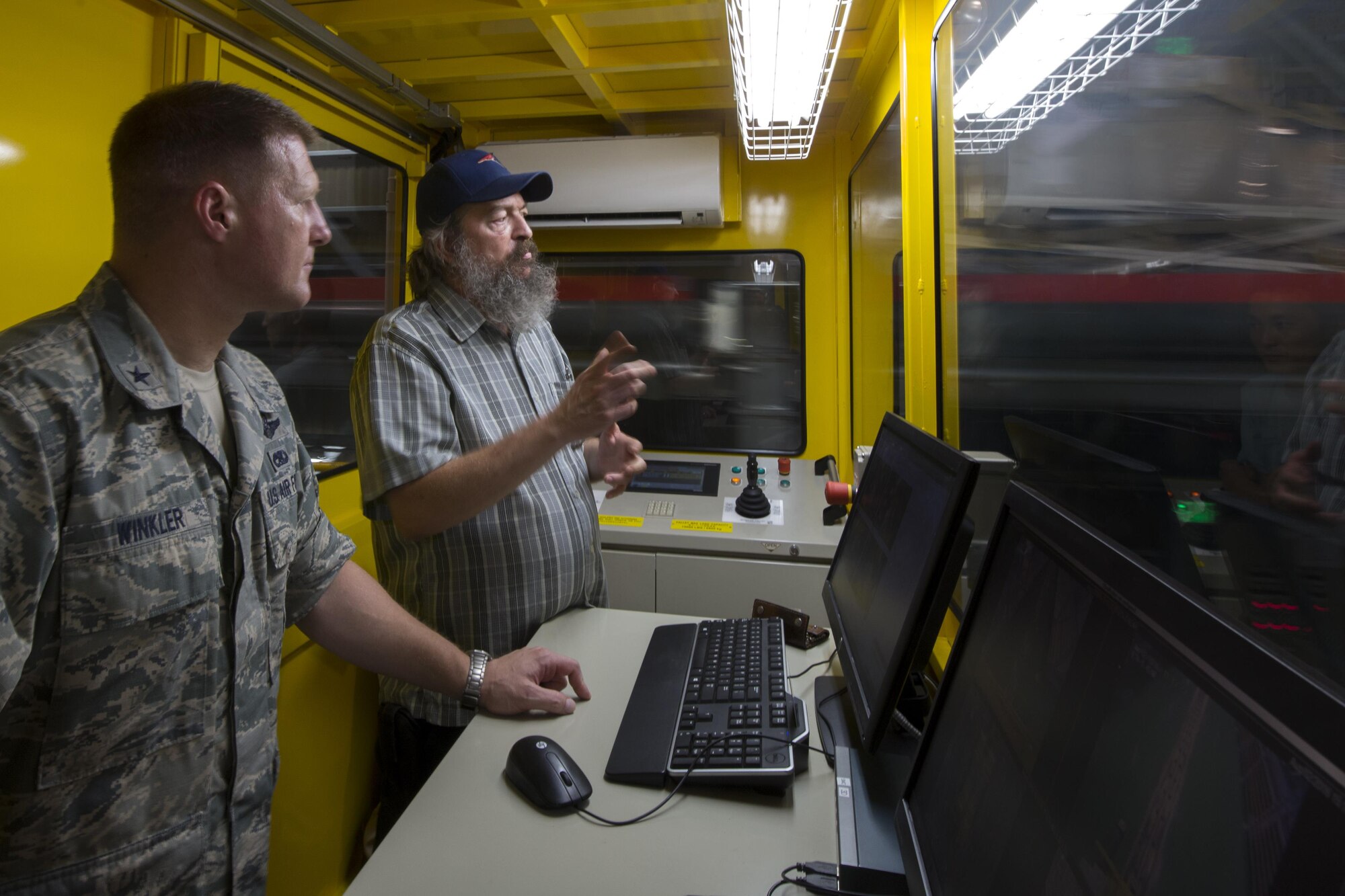 Brig. Gen. Michael Winkler, 5th Air Force vice commander, is briefed by Dean Labdon, 730th Air Mobility Squadron mechanized material handling system manager, on the MMHS capabilities at Yokota Air Base, Japan, Aug. 2, 2016, during his immersion tour. The automated system sorts, records and stores pallets in the warehouse based on their destination. (U.S. Air Force photo by Yasuo Osakabe/Released) 