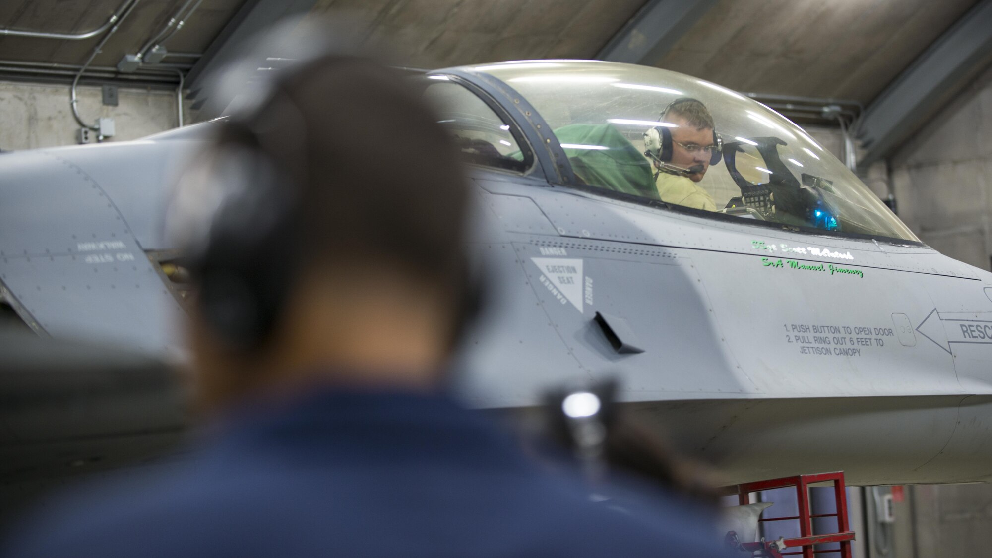 Staff Sgts. Andrew Beavers and Johnathan Lewis, 31st Maintenance Squadron phase crew chiefs, communicate with one another during a diagnostics test on an F-16 Fighting Falcon July 28, 2016, at Aviano Air Base, Italy. The 31st MXS hush house is open for engine diagnostics testing 24-hours a day. (U.S. Air Force photo by Airman 1st Class Cory W. Bush/Released)