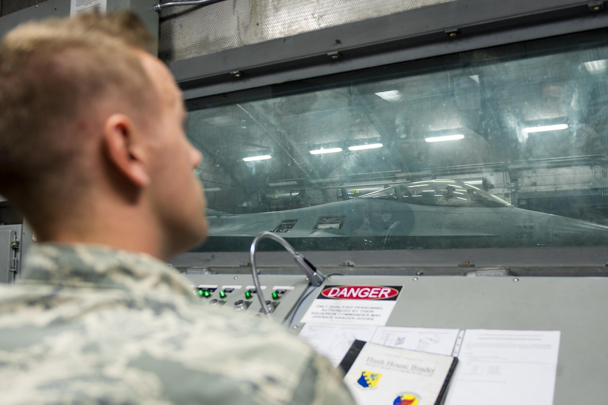 Tech. Sgt. Dustin Allsbrook, 31st Maintenance Squadron phase dock chief, monitors an F-16 Fighting Falcon during an engine diagnostics test in a hush house July 28, 2016, at Aviano Air Base, Italy. The hush house is an enclosed structure made of noise suppression material and is used to test turbine engines. (U.S. Air Force photo by Airman 1st Class Cory W. Bush/Released)