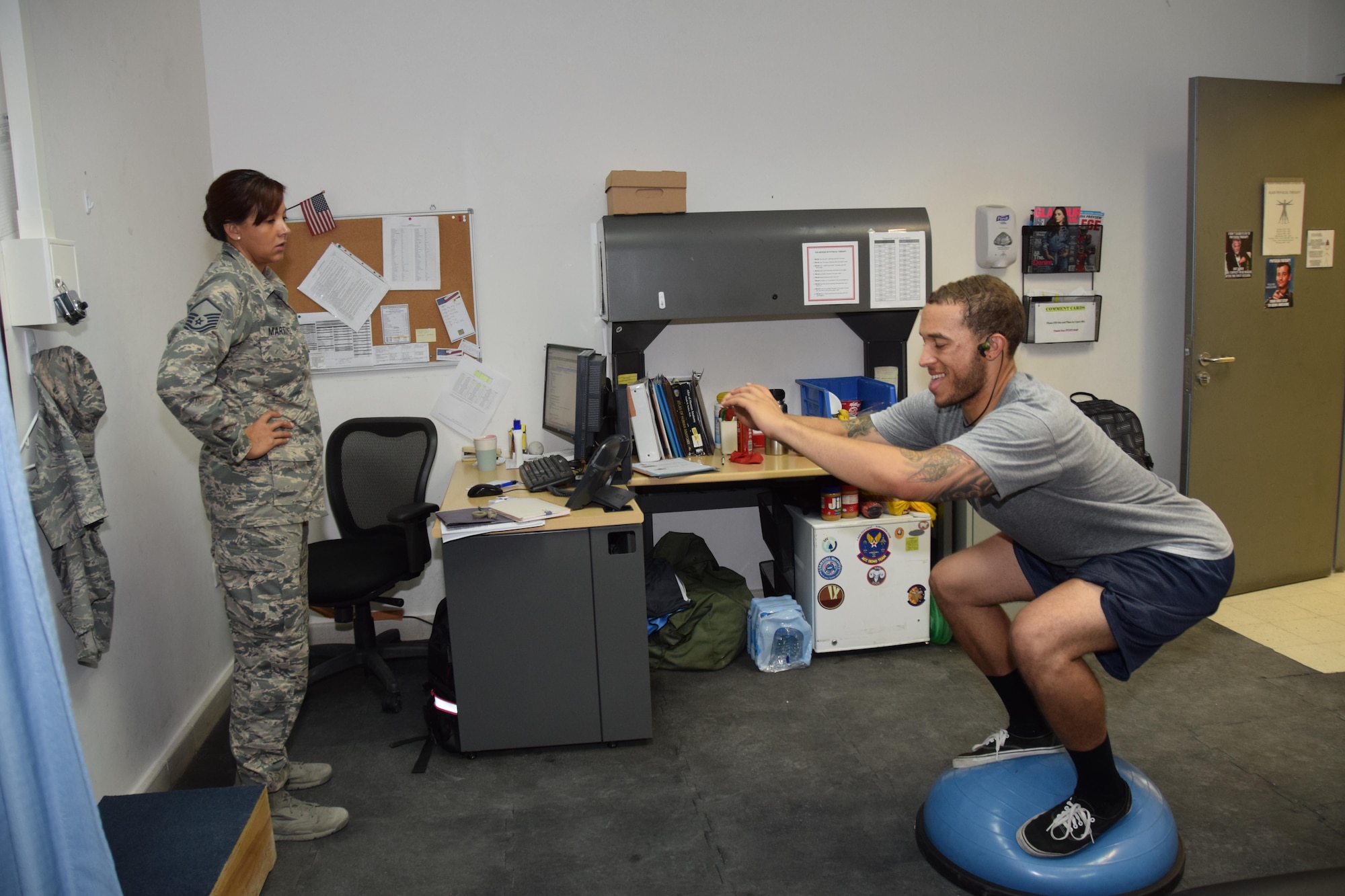 U.S. Army Sgt. Karl Hawthorne, Combined Air Operations Center air defense communications and tactics specialist, trains on a Bosu ball to develop muscular stability as Master Sgt. Stephanie A. Martinez, 379th Expeditionary Medical Operations Squadron physical therapy assistant, monitors him. Hawthorne used a Bosu ball to add a stability element to an exercise ensuring his core muscles work harder. (U.S. Air Force photo/Technical Sgt. Carlos J. Treviño/Released)