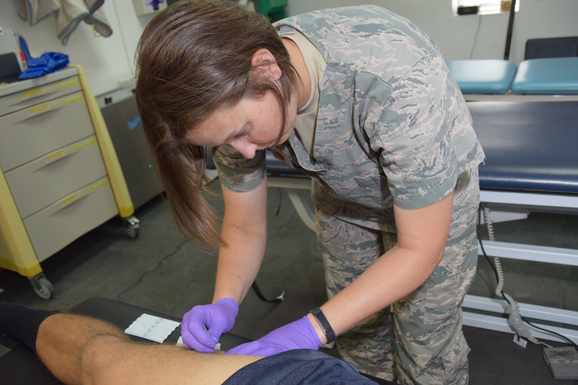 Maj. Erin R. Sturgell, 379th Expeditionary Medical Operations Squadron physical therapist, uses dry needling on the quadriceps of U.S. Army Sgt. Karl Hawthorne, Combined Air Operations Center air defense communications and tactics specialist, July 28, 2016, at Al Udeid Air Base, Qatar. Dry needling treats muscular dysfunction and is a healing technique used to relieve pain and helps muscle fibers to reset and restore their function. (U.S. Air Force photo/Technical Sgt. Carlos J. Treviño/Release)