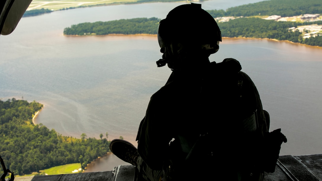 Cpl. Dunbar Linell, a crew chief with Marine Heavy Helicopter Squadron 461, observes his surroundings for an acceptable landing zone at Marine Corps Air Station New River, N.C., July 28, 2016. The CH-53E Super Stallion is the largest helicopter in the United States military, and able to carry a 26,000-pound Light Armored Vehicle, 16 tons of cargo, or enough combat-loaded Marines to lead an assault or humanitarian operation. The capabilities provided by the CH-53E strengthen the expeditionary capabilities of Marines Corps units and make this aircraft one of the most useful in the Marine Corps. HMH-461 is part of Marine Aircraft Group 29, 2nd Marine Aircraft Wing. 