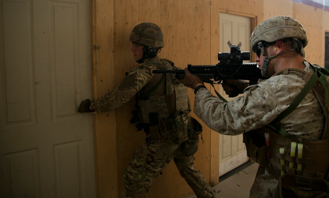 Cpl. Micah Shaw, a member of 5th Plt., Charlie Co., Fleet Anti-Terrorism Support Team, Marine Corps Security Force Regiment, provides security as a Royal Commando prepares to enter a room during Tartan Eagle 16 at the Northumbria Tactical Training Center in Northumbria, England, July 25, 2016. Tartan Eagle is an annual training event that began in 1994. The CQB portion of Tartan Eagle allowed  Marines and sailors to integrate with their British counterparts and exchange tactics while also learning new tactics. Marines and sailors trained with the 43 Command Fleet Protection Group Royal Marine commandos to exchange best security and training practices and to foster good relations between the two commands. (Official Marine Corps photo by Sgt. Calvin Shamoon/Released)