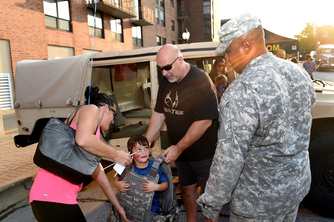 Local residents meet Army Reserve Maj. Lawrence Reid, 85th Support Command, in front of his Humvee during National Night Out community police event held in Arlington Heights, Illinois on August 2, 2016. National Night Out is a national observance across the U.S. and Canada on the second Tuesday of every August. 
(U.S. Army photo by Sgt. Aaron Berogan/Released)