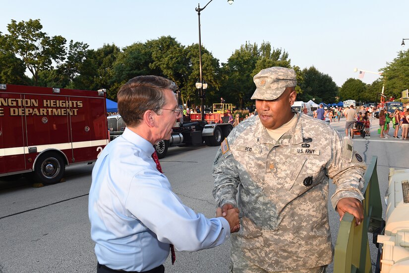 Mayor Tom Hayes, left, Mayor, Village of Arlington Heights, stops to shake hands with Army Reserve Maj. Lawrence Reid, Resource Management Officer, 85th Support Command, during Arlington Heights’ National Night Out police community event on August 2, 2016. Hayes is a retired lieutenant colonel from the Army Reserve.
(U.S. Army photo by Sgt. Aaron Berogan/Released)