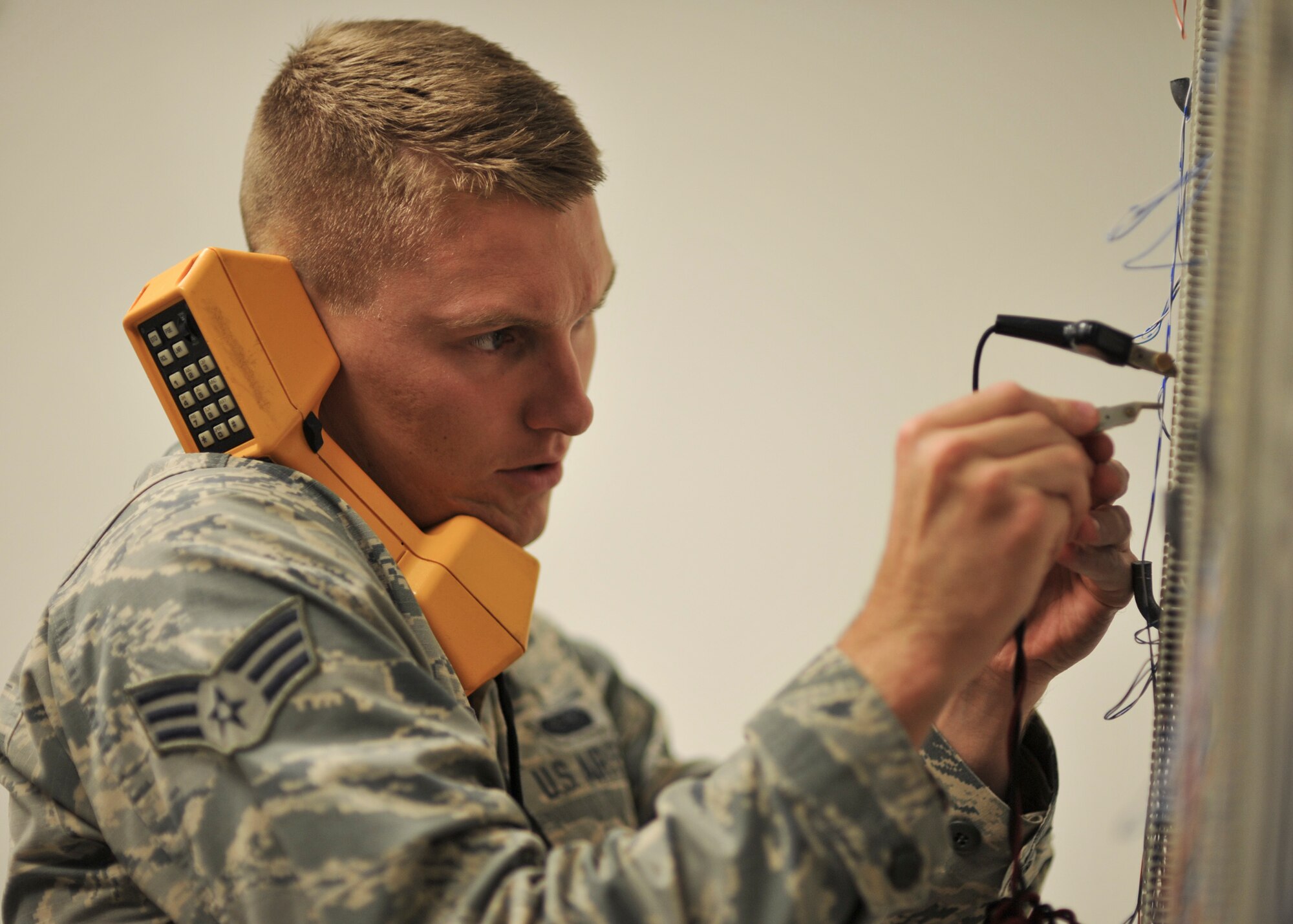 U.S. Air Force Senior Airman Tory Osmundson, 325th Communications Squadron client systems technician, performs maintenance on a phone line in the 325th CS Annex on Tyndall Air Force Base, Fla., Aug. 3, 2016. Whenever a customer has a problem with a phone or computer, Osmundson and his shop are responsible for fixing it. (U.S. Air Force photo by Senior Airman Dustin Mullen/Released)