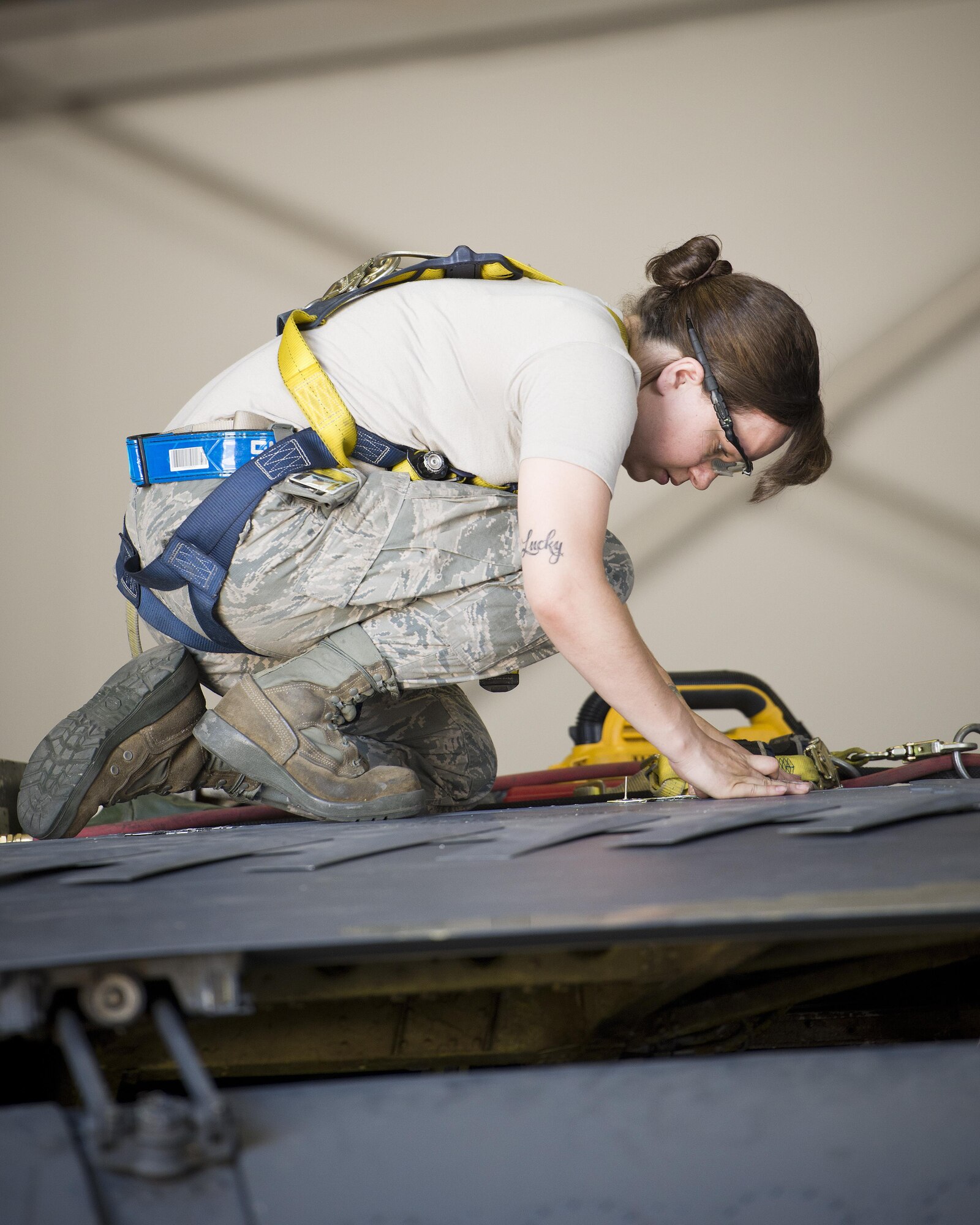 Senior Airman Amanda Scanlan, 5th Maintenance Squadron aircraft structural maintenance, inspects a patch on a spoiler atop the wing of a B-52H Stratofortress at Minot Air Force Base, N.D., August 2, 2016. Yellow sheet metal patches are riveted down to repair cracked spoilers on the B-52s.  (U.S. Air Force photo/Airman 1st Class J.T. Armstrong)