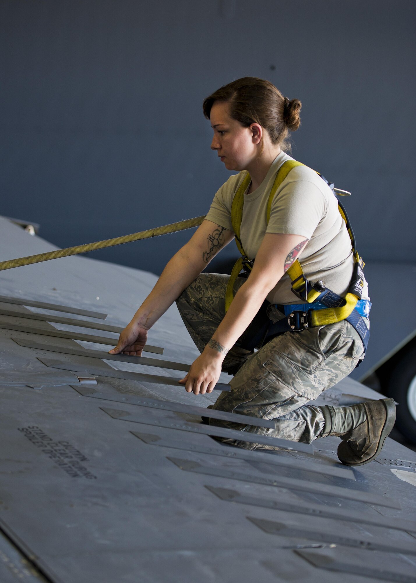 Senior Airman Amanda Scanlan, 5th Maintenance Squadron aircraft structural maintenance, lifts a spoiler atop the wing of a B-52H Stratofortress at Minot Air Force Base, N.D., August 2, 2016. Scanlan must check the aircraft for foreign objects and debris after making repairs. (U.S. Air Force photo/Airman 1st Class J.T. Armstrong)