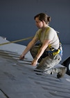 Senior Airman Amanda Scanlan, 5th Maintenance Squadron aircraft structural maintenance, lifts a spoiler atop the wing of a B-52H Stratofortress at Minot Air Force Base, N.D., August 2, 2016. Scanlan must check the aircraft for foreign objects and debris after making repairs. (U.S. Air Force photo/Airman 1st Class J.T. Armstrong)