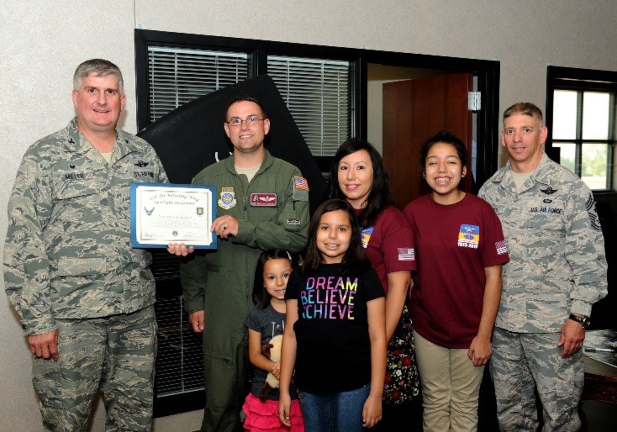 Tech. Sgt. Marcus Barnes, 384th Air Refueling Squadron operations superintendent, poses with Col. Albert Miller, 22nd Air Refueling Wing commander, Chief Master Sgt. Shawn Hughes, 22nd ARW command chief, and his family, July 26, 2016, at McConnell Air Force Base, Kan. Barnes received the spotlight performer for the week of June 20 - 24. (U.S. Air Force photo/Senior Airman David Bernal Del Agua)