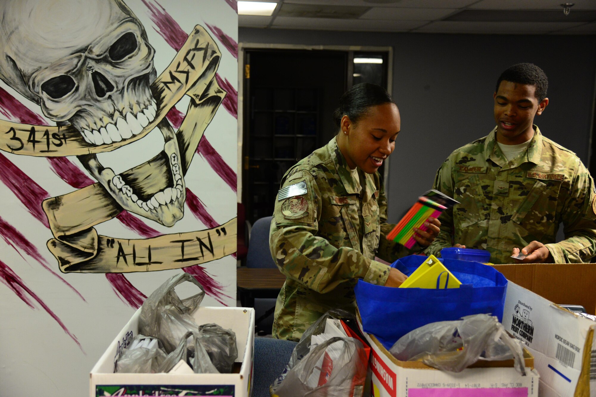 Airman 1st Class Shante Adkins, left, and Airman Bradley Calhoun, right, both assigned to the 341st Missile Security Forces Squadron, donate back to school items Aug. 4, 2016, at Malmstrom Air Force Base, Mont. The 341st MSFS held a back-to-school donation drive to offset the cost of supplies for families. (U.S. Air Force photo/Airman 1st Class Magen M. Reeves) 