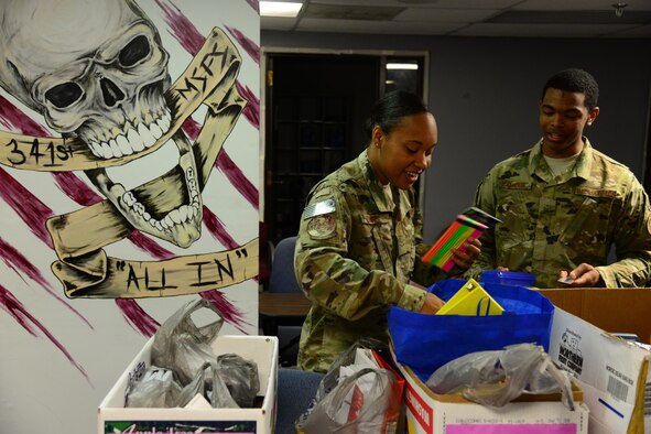 Airman 1st Class Shante Adkins, left, and Airman Bradley Calhoun, right, both assigned to the 341st Missile Security Forces Squadron, donate back to school items Aug. 4, 2016, at Malmstrom Air Force Base, Mont. The 341st MSFS held a back-to-school donation drive to offset the cost of supplies for families. (U.S. Air Force photo/Airman 1st Class Magen M. Reeves) 