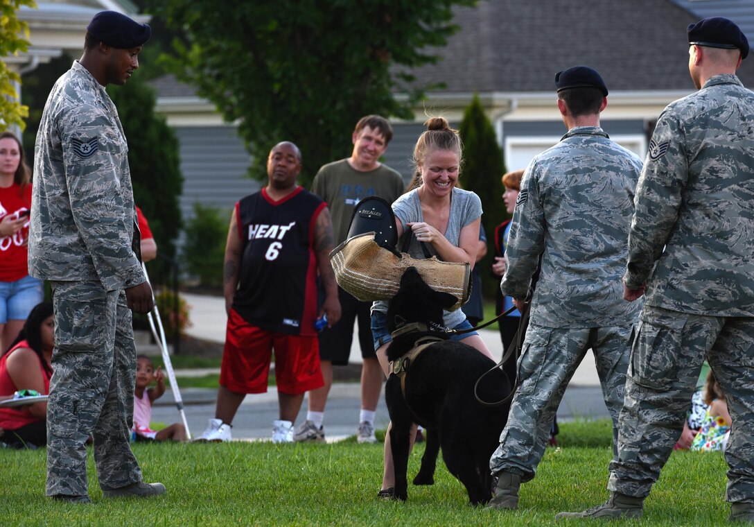 Melissa Arbor, wife of Staff Sgt. Matthew Arbor, experiences what it’s like to be attacked by a military working dog during a National Night Out event held at the Liberty Park welcome center on Joint Base Andrews, Md., Aug. 2, 2016. The event had demonstrations from various units on base, including the 11th Civil Engineer Squadron Fire Department and 11th Security Forces Squadron. (U.S. Air Force photo by Airman Gabrielle Spalding)