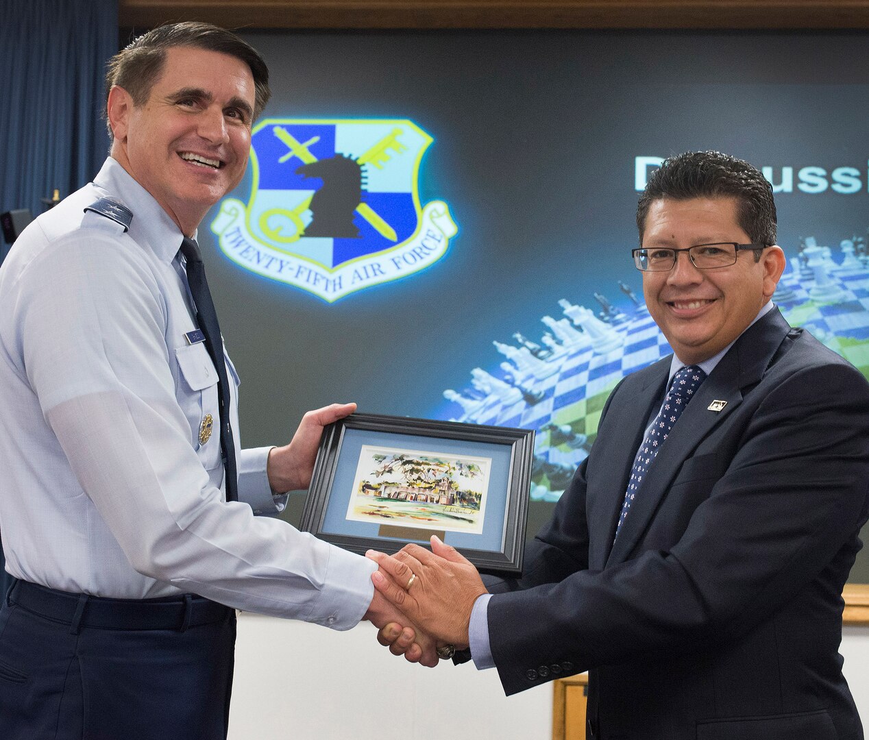 San Antonio Chamber of Commerce President Richard Perez presents Maj. General. Bradford “BJ” Shwedo with an original watercolor of a historic San Antonio mission during the Chamber’s vist to 25th Air Force headquarters, JBSA-Lackland, Friday.