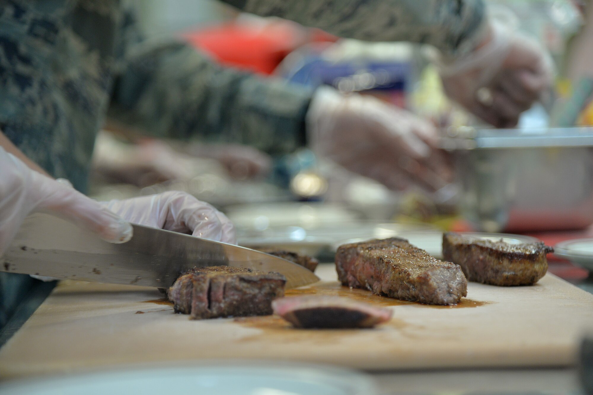 Airman 1st Class Alisha Hubbard, 341st Force Support Squadron missile chef, serves steak during the Warrior Chef competition Aug. 3, 2016 at Malmstrom Air Force Base, Mont. The teams had to prepare six servings of each dish from scratch and present them to five judges who critiqued on taste, texture, tenderness, creativity, presentation and use of the secret ingredient. (U.S. Air Force photo/Airman 1st Class Daniel Brosam)