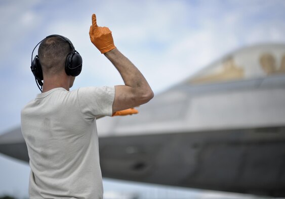U.S. Air Force Staff Sgt. Michael Clayton, 43rd Aircraft Maintenance Squadron F-22 Raptor crew chief, directs an F-22 pilot out of his parking space prior to taxiing down the flightline during Sentry Savannah 16-3 in Savannah, Ga. Aug. 1, 2016. Sentry Savannah is an exercise that focuses on dissimilar air combat training, which gives units the opportunity to train with and against multiple unique aircraft. (U.S. Air Force photo by Senior Airman Solomon Cook/Released)