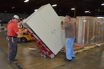 Material handlers Danny Howard and Charles Gonzalez, Defense Logistics Agency Installation Support at Richmond, move a cabinet for delivery to an office at Defense Supply Center Richmond. Office moves, furniture delivery and cube construction are a few of the services provided by the Customer Support Division. 
