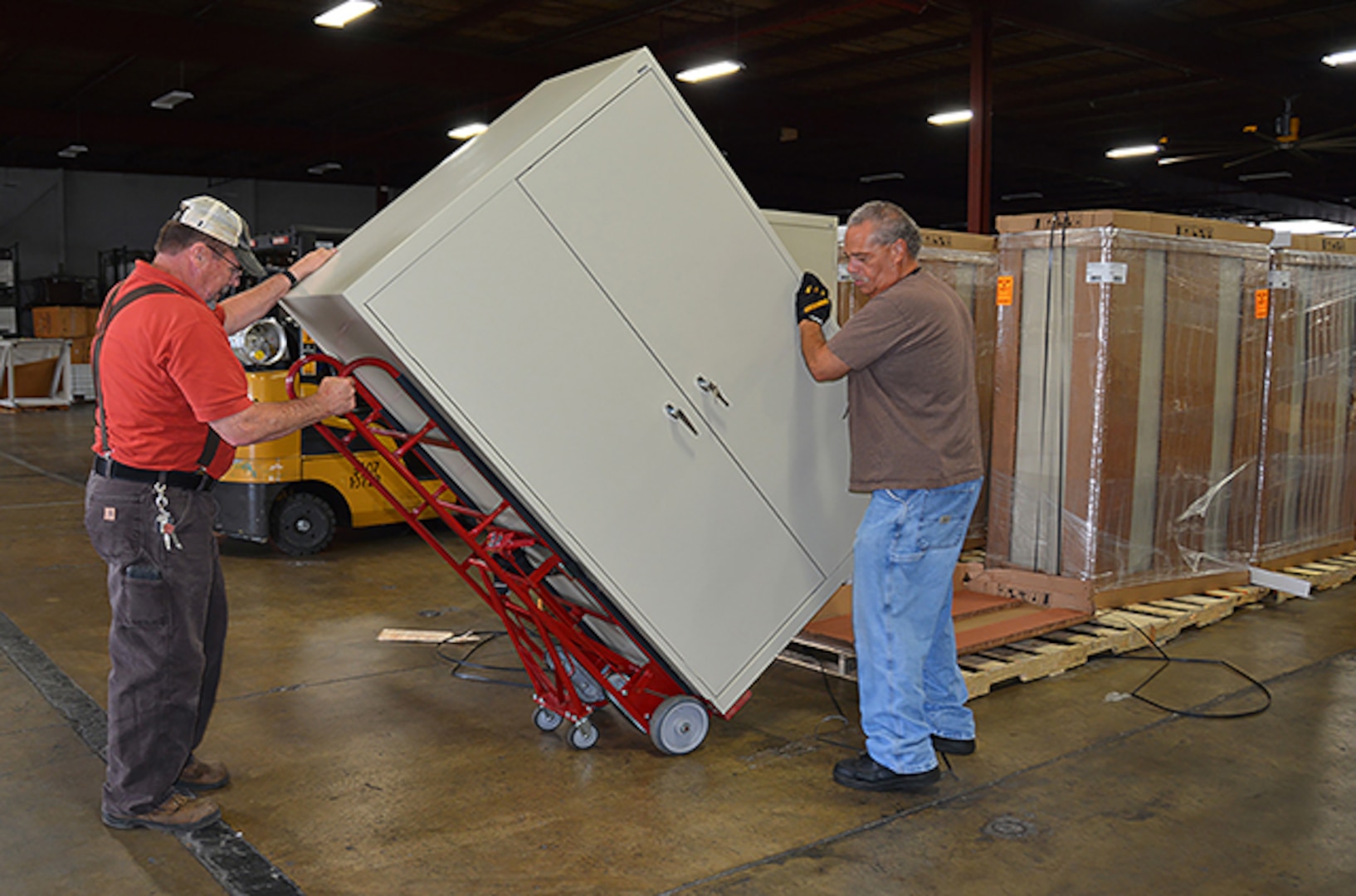 Material handlers Danny Howard and Charles Gonzalez, Defense Logistics Agency Installation Support at Richmond, move a cabinet for delivery to an office at Defense Supply Center Richmond. Office moves, furniture delivery and cube construction are a few of the services provided by the Customer Support Division. 