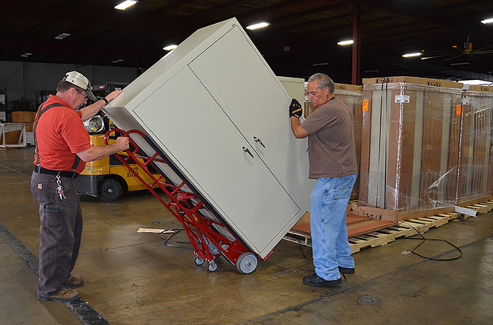 Material handlers Danny Howard and Charles Gonzalez, Defense Logistics Agency Installation Support at Richmond, move a cabinet for delivery to an office at Defense Supply Center Richmond. Office moves, furniture delivery and cube construction are a few of the services provided by the Customer Support Division. 