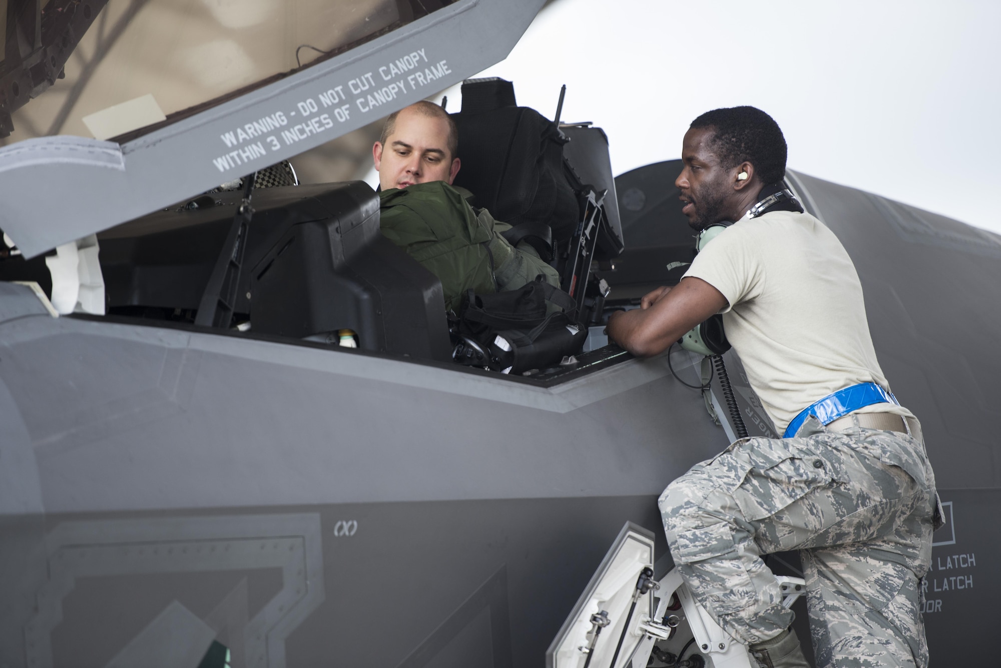 (Right) Airman 1st Class Lonnie Prater, 58th Aircraft Maintenance Unit assistant dedicated crew chief, speaks to (Left) Lt. Col. Brian O’Grady, 58th Fighter Squadron assistant director of operations, prior to take off during a sortie surge Aug. 2, 2016, at Eglin Air Force Base, Fla. The 33rd Fighter Wing completed 111 sorties during a three-day surge to exercise the readiness of pilots, maintainers and aircraft to meet the needs of high-tempo operations. (U.S. Air Force photo by Senior Airman Stormy Archer)