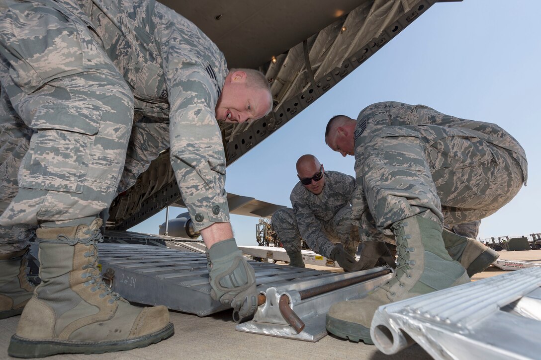 U.S. Air Force Tech. Sgt. Ahbe Coates (left), Staff Sgt. Josh Crooks (center) and Tech. Sgt. Robert Terry, assigned to the 266th Range Squadron, Mountain Home Air Force Base, Idaho, prepare the ramp extension on a Royal Australian Air Force (RAAF) C-17A Globemaster III during Pitch Black 16 at RAAF Base Darwin, Australia, Aug. 2, 2016. Pitch Black is a biennial multinational air warfare exercise hosted by the RAAF that focuses on offensive counter air and defensive counter air combat in a simulated war environment. (Australian Defence Force photo by Cpl. David Gibbs)