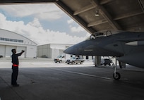 U.S. Air Force Airman 1st Class Marc Hicks, 18th Aircraft Maintenance Squadron crew chief, guides an F-15 Eagle July 29, 2016, at Kadena Air Base, Japan. The Eagle was piloted by Lt. Col. James McFarland, 67th Fighter Squadron commander, when it reached its 10,000 flight hours mark. This flight was also McFarland’s final flight as the commander. (U.S. Air Force photo by Airman 1st Class Lynette M. Rolen)