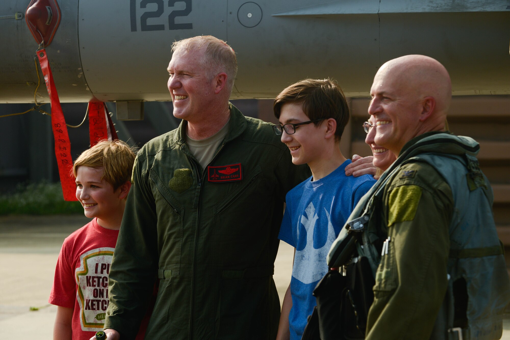 Col. Brian Carr, 51st Fighter Wing vice commander, poses for a photo with Col. Andrew Hansen, 51st FW commander, and his family following his final flight in an F-16 Fighting Falcon at Osan Air Base, Republic of Korea, Aug. 4, 2016. Family and coworkers gathered onto the flightline to congratulate Carr on his retirement. (U.S. Air Force photo by Senior Airman Dillian Bamman)
