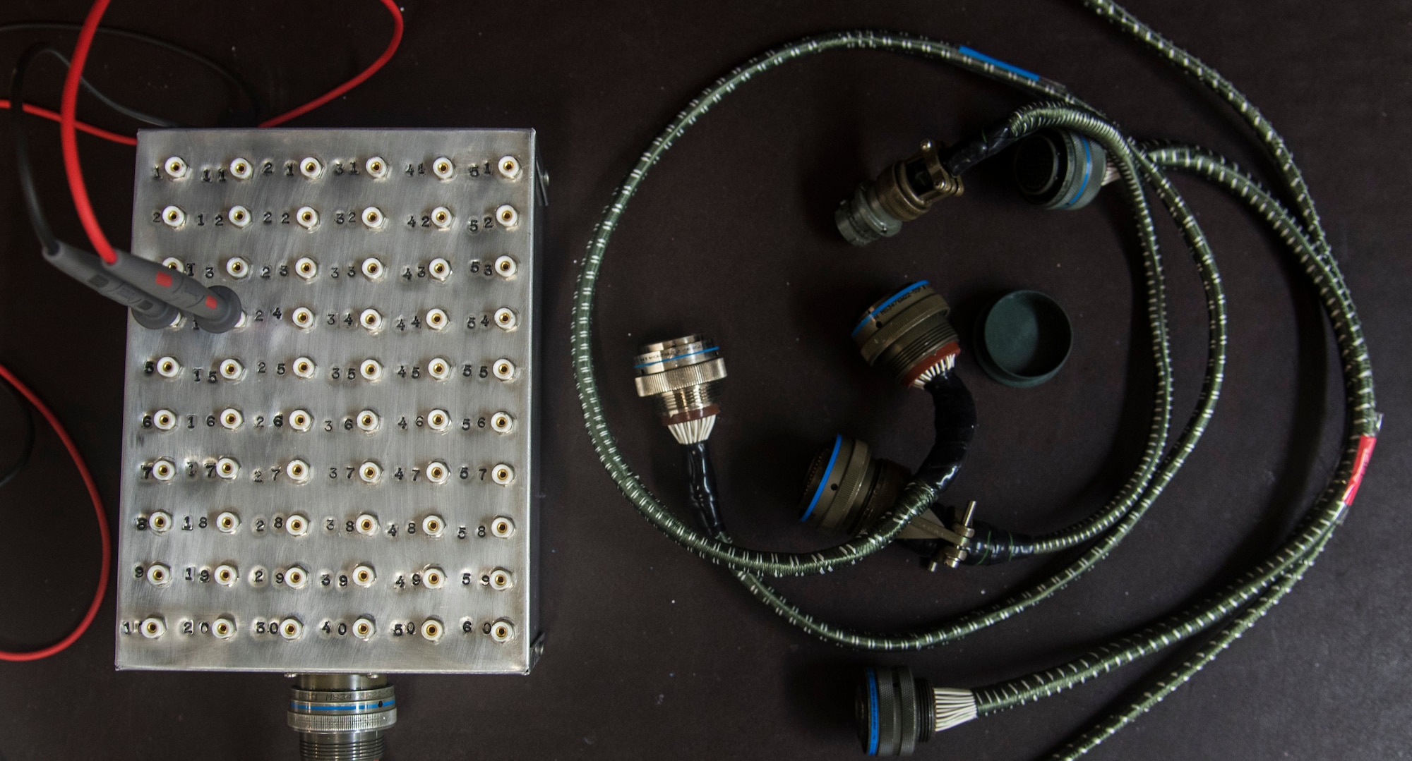 A breakout box and line replaceable unit extension cables lie on a counter in the avionics shop at Misawa Air Base, Japan, Aug. 1, 2016. The device was created by the 35th Maintenance Squadron avionics flight to help speed up continuity checks on LRUs which inspect the integrity of electrical pathways. LRUs are aircraft parts found in F-16 Fighting Falcons that allow a pilot to interact with the jet. (U.S. Air Force photo by Senior Airman Jordyn Fetter)