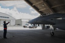 U.S. Air Force Airman 1st Class Marc Hicks, 18th Aircraft Maintenance Squadron crew chief, guides an F-15 Eagle July 29, 2016, at Kadena Air Base, Japan. The Eagle was piloted by Lt. Col. James McFarland, 67th Fighter Squadron commander, when it reached its 10,000 flight hours mark. This flight was also McFarland’s final flight as the commander. (U.S. Air Force photo by Airman 1st Class Lynette M. Rolen)