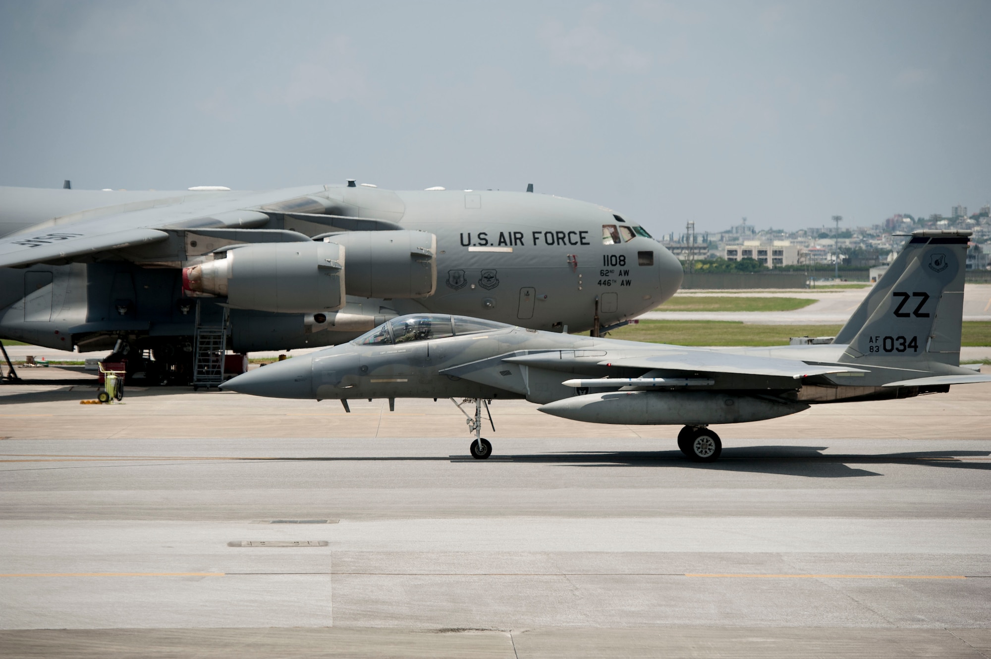 A 44th Fighter Squadron F-15 Eagle taxis past a C-17 Globemaster III assigned to Joint Base Lewis-McChord, Wash., July 28, 2016, at Kadena Air Base, Japan. Kadena supports Air Force commitments in the Pacific region as well as all U.S. and allied partner interests from all over the world. (U.S. Air Force photo by Senior Airman Peter Reft)