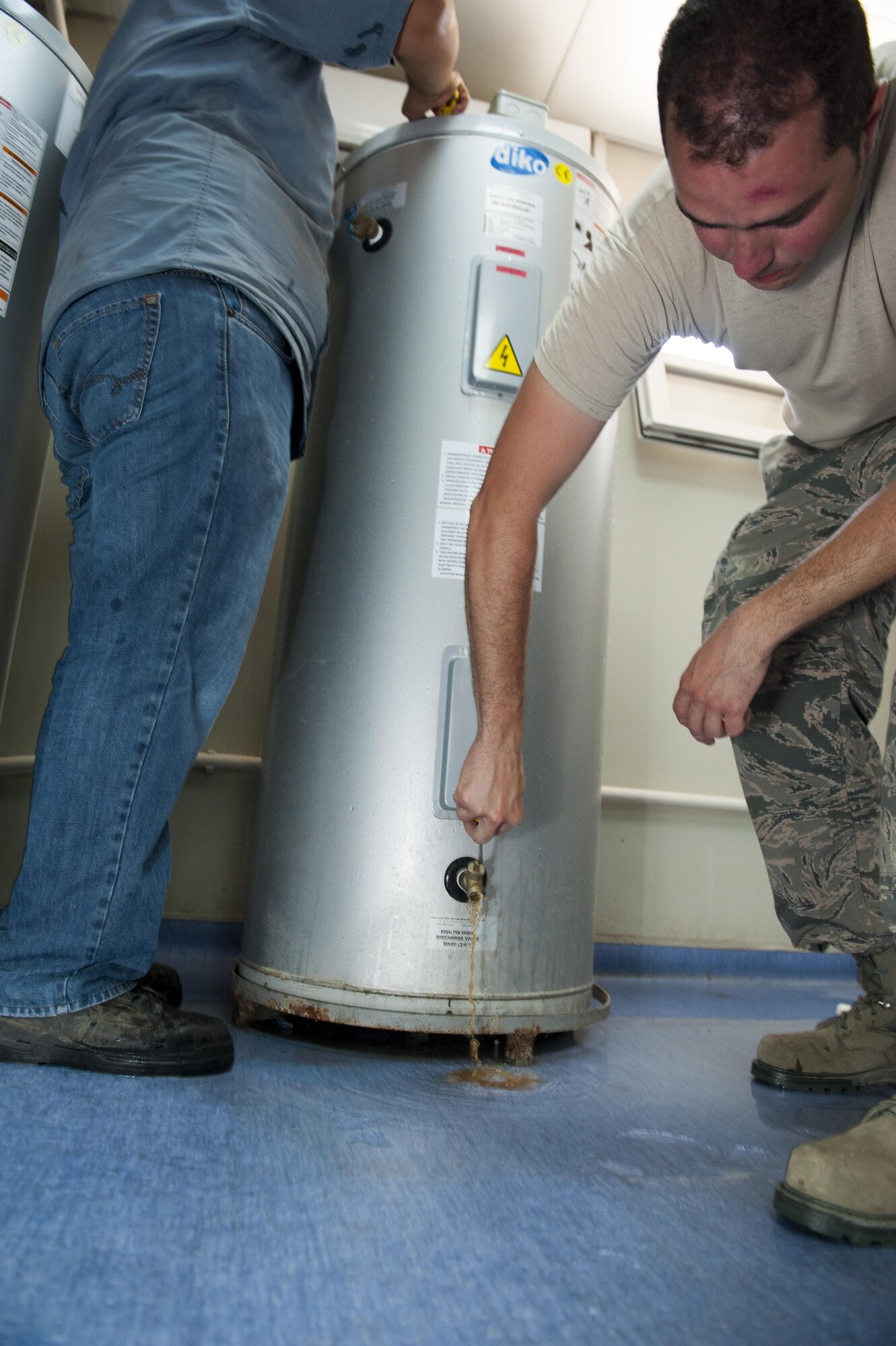 U.S. Air Force Staff Sgt. Ryan Bombardiere, 48th Civil Engineer Squadron (CES) water fuels system maintenance technician, drains water from a water heater July 28, 2016, at Incirlik Air Base, Turkey. Servicemembers from across U.S. Air Forces in Europe-Air Forces Africa came on temporary duty after a request for forces was submitted by the 39th CES. (U.S. Air Force photo by Staff Sgt. Jack Sanders)