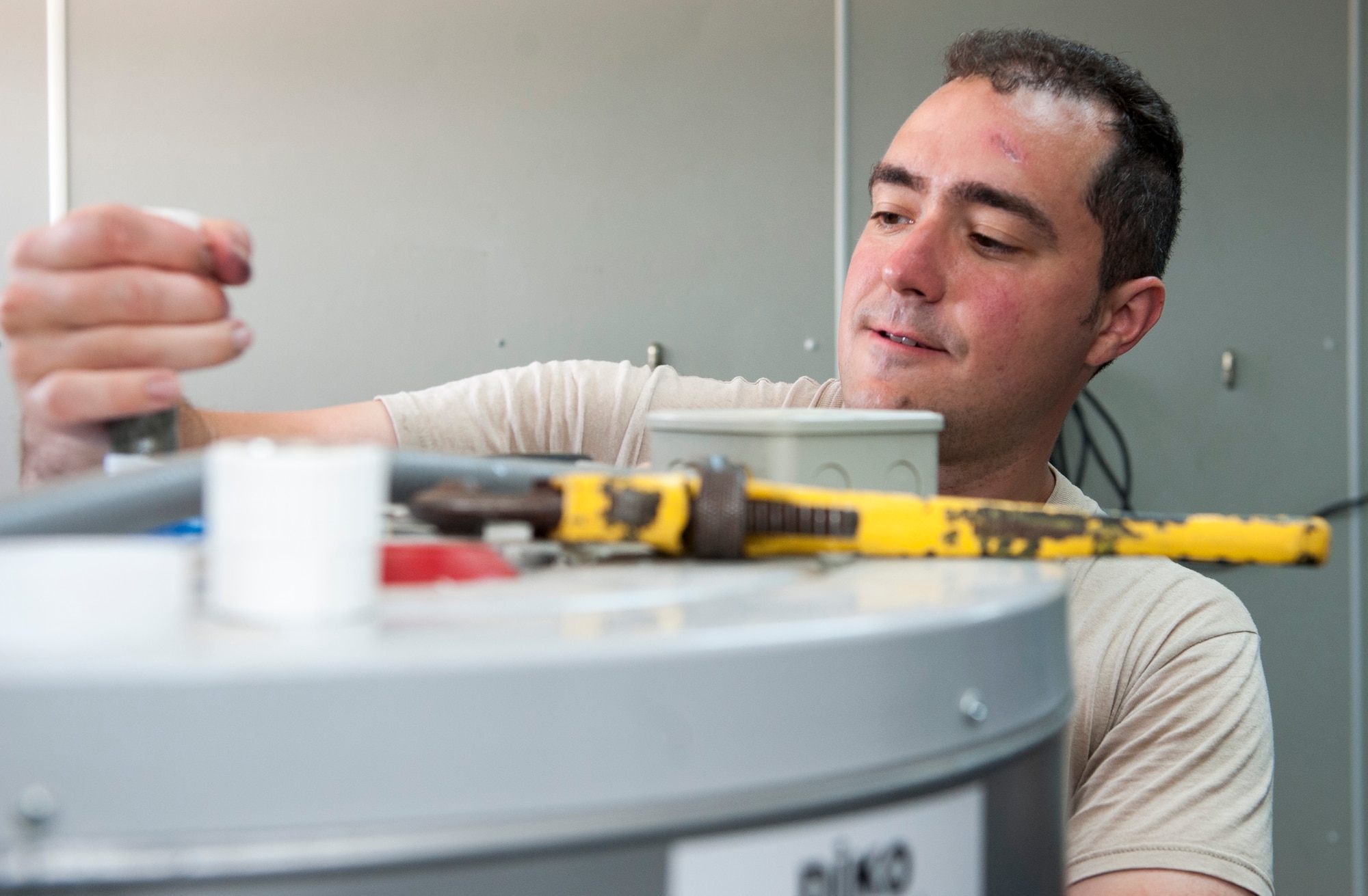 U.S. Air Force Staff Sgt. Ryan Bombardiere, 48th Civil Engineer Squadron (CES) water fuels system maintenance technician, repairs a water heater July 28, 2016, at Incirlik Air Base, Turkey. Servicemembers from across U.S. Air Forces in Europe-Air Forces Africa came on temporary duty after a request for forces was submitted by the 39th CES. (U.S. Air Force photo by Staff Sgt. Jack Sanders)