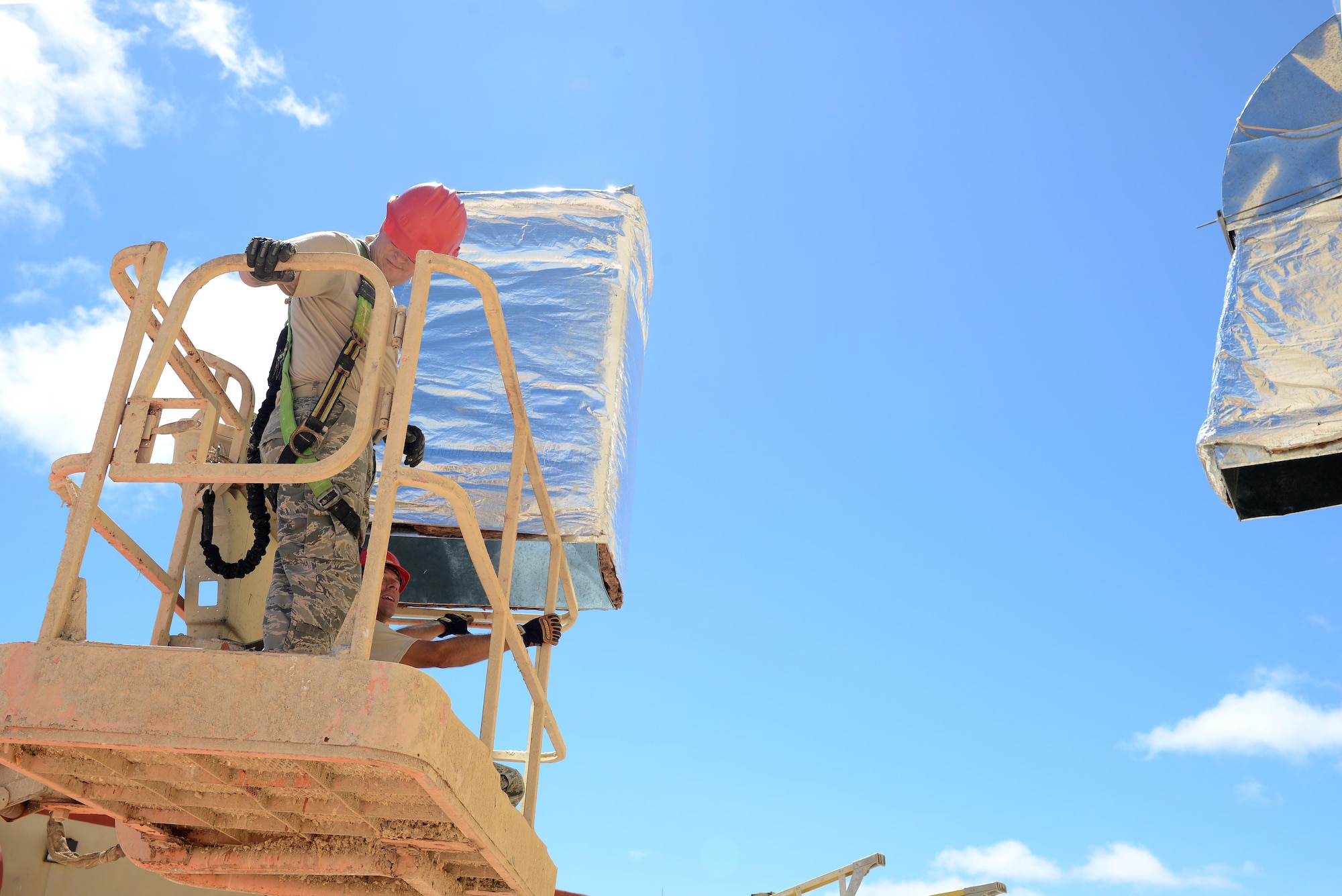 Tech. Sgt. Lonnie Battenfield, left, 556th RED HORSE Squadron utilities craftsman, and Staff Sgt. Mathew Scroggins, 556th RHS operations management technician, transport an exterior duct section to the Explosive Ordnance Disposal warehouse July 20, 2016, at Andersen Air Force Base, Guam. The EOD warehouse will be utilized for Silver Flag training and will store items such as Humvees, bomb suits, EOD robots and training equipment. (U.S. Air Force photo/Airman 1st Class Arielle Vasquez)