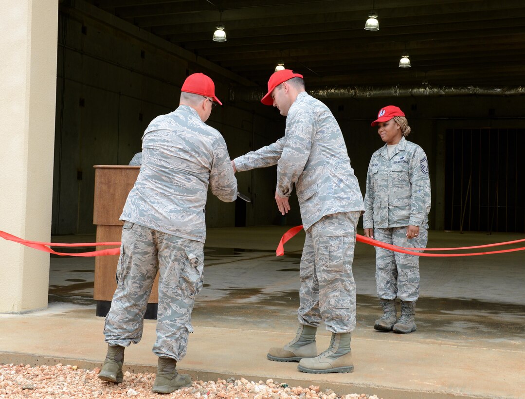 Col. Dale Fox, left, 556th RED HORSE Squadron commander, and Maj. Jarrett Gafford, 554th RED HORSE Squadron commander, cut a ribbon commemorating the completion of an EOD warehouse July 26, 2016, at Andersen Air Force Base, Guam. A total of 250 military members and engineers worked on the project, which took approximately 34,500 man-hours to complete. (U.S. Air Force photo/Airman 1st Class Arielle Vasquez) 