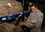 Airman 1st Class Juan Robalino, 379th Expeditionary Logistics Readiness Squadron Desert Depot, inventories uniforms at Al Udeid Air Base, Qatar Dec. 3. A new audit ready inventory resolution process ensures material availability for Clothing and Textiles military customers by streamlining the way transaction failures are reconciled.
