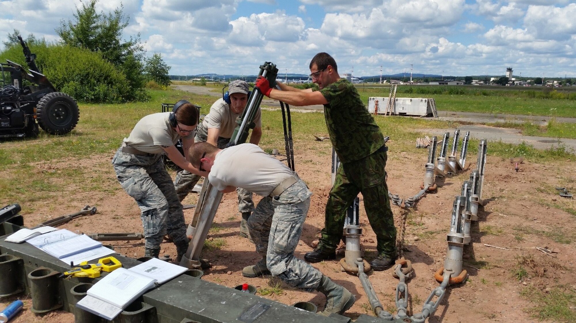 Airmen from the 435th Construction and Training Squadron and a Lithuanian airman participate in a training exercise with a Mobile Aircraft Arresting System July 20, 2016, at Ramstein Air Base, Germany. The MAAS is intended to be installed at expeditionary airfields and enables fighter pilots to safely land in the event of an in-flight emergency due to aircraft equipment failures. (U.S. Air force courtesy photo)