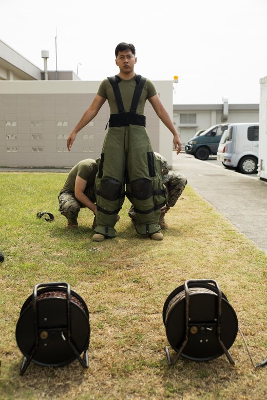 U.S. Marine Corps Sgt. Samnang Chang, a Marine security guard with the Marine Corps Embassy Security Group at the U.S. Embassy in Tokyo, Japan, is dressed with an EOD-9 Advanced Bomb Suit before performing the bomb suit agility test during his EOD technician screening process outside the EOD building at Marine Corps Air Station Iwakuni, Aug. 2, 2016. The bomb suit agility test evaluates the Marine’s ability to stay calm and perform physical, mental and memorization exercises in the heavy and claustrophobic environment of the EOD-9 ABS. (U.S. Marine Corps photo by Lance Cpl. Donato Maffin)  