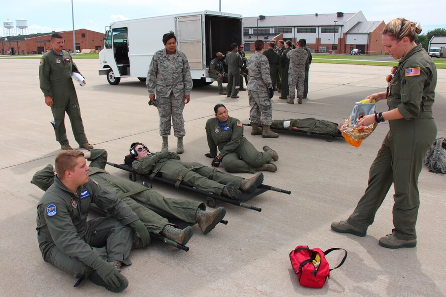 Leading people in the summer heat, Staff Sgt. Sarah Trost, 932nd Aeromedical Evacuation Squadron, explains the safety procedures to don an oxygen mask in case of smoke or fire to her "simulated patients" as they wait to board a C-130 from the 908th Airlift Wing, visiting from Maxwell Air Force Base, Alabama.  Both the 932nd Airlift Wing and 908th Airlift Wing flew together to get medical training time in the air, and both are units under 22nd Air Force and the Air Force Reserve Command.  Known as the "Gateway Wing", the 932nd Airlift Wing at Scott Air Force Base is located less than 30 minutes from the Saint Louis Arch and reservists live on both sides of the Mississippi River.  (U.S. Air Force photo by Maj. Stan Paregien)